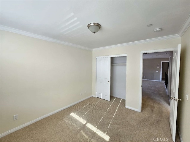 unfurnished bedroom with crown molding, carpet, and a closet