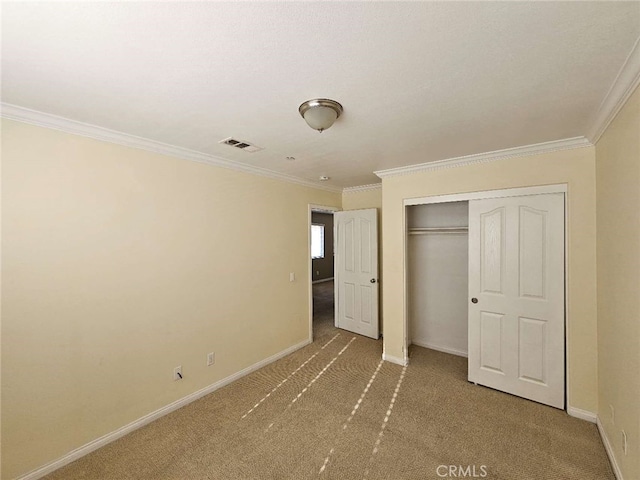 unfurnished bedroom with ornamental molding, carpet flooring, and a closet