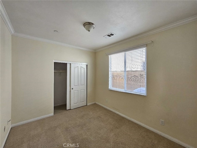 unfurnished bedroom featuring crown molding, light carpet, and a closet