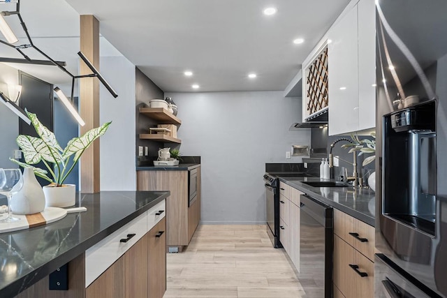 kitchen featuring white cabinetry, black dishwasher, sink, dark stone counters, and light wood-type flooring