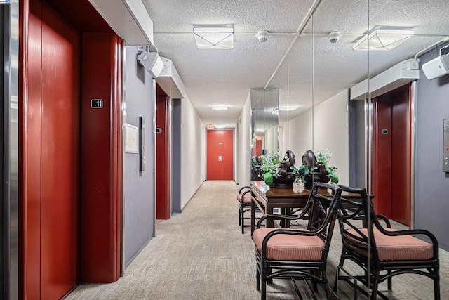 corridor with elevator and a textured ceiling