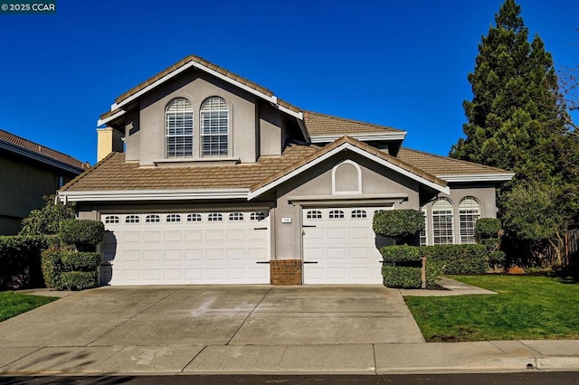 view of property featuring a garage and a front yard