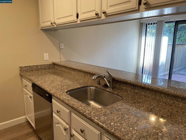 kitchen featuring sink, dark wood-type flooring, dishwasher, white cabinetry, and dark stone counters