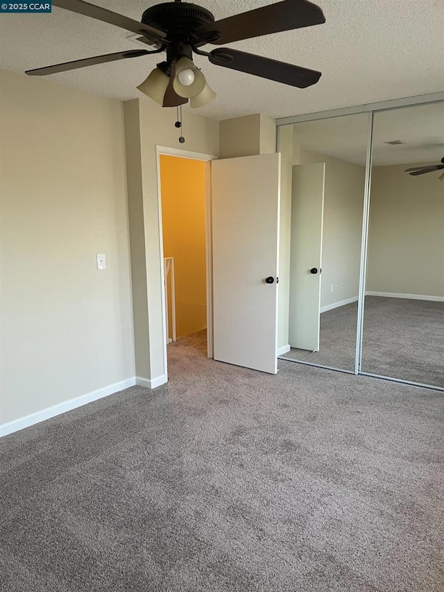 unfurnished bedroom featuring carpet flooring, a textured ceiling, ceiling fan, and a closet