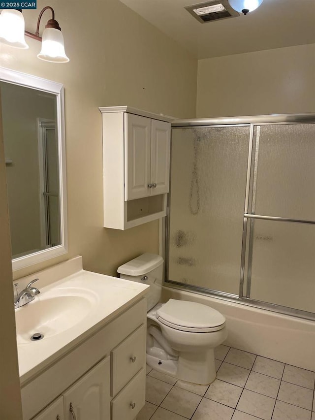 full bathroom with enclosed tub / shower combo, toilet, tile patterned floors, and vanity