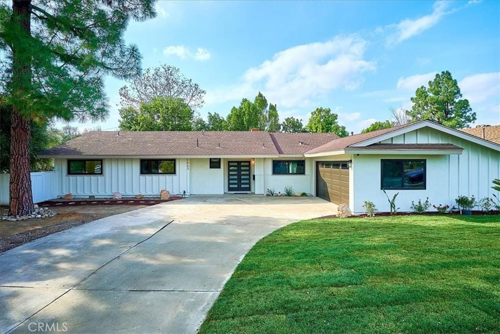 ranch-style home with a garage and a front lawn