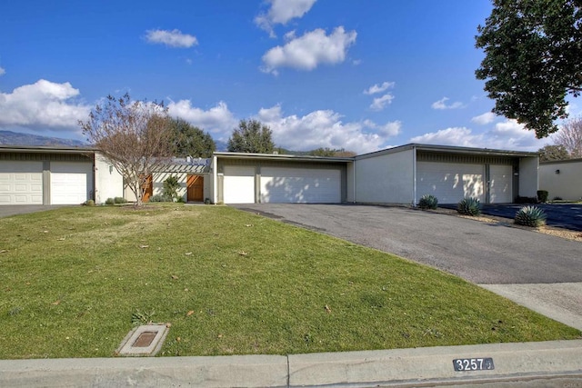 single story home featuring a garage and a front lawn