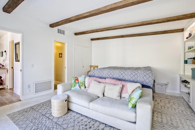 carpeted bedroom with beamed ceiling