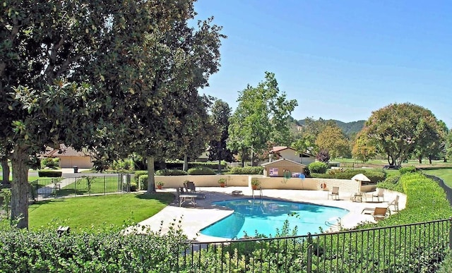 view of pool featuring a mountain view, a lawn, and a patio