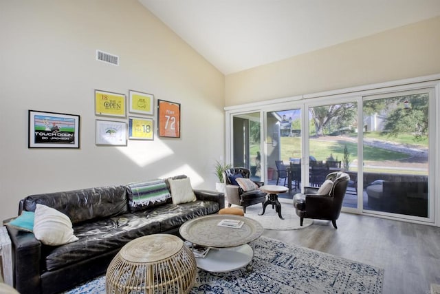 living room with hardwood / wood-style floors and high vaulted ceiling