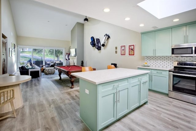 kitchen featuring tasteful backsplash, stainless steel appliances, light hardwood / wood-style floors, and green cabinetry