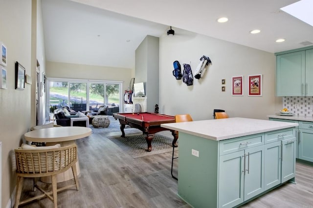 interior space featuring vaulted ceiling, pool table, and light hardwood / wood-style floors