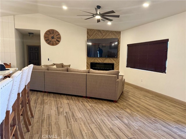 living room featuring a large fireplace and ceiling fan