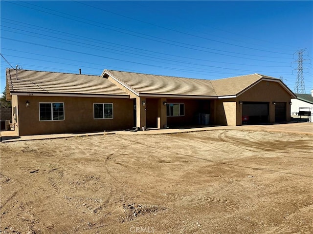 single story home with central air condition unit and a garage