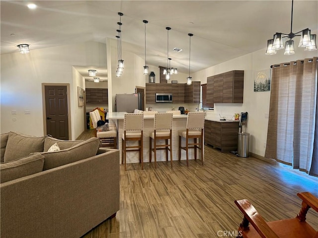 dining space with high vaulted ceiling and wood-type flooring