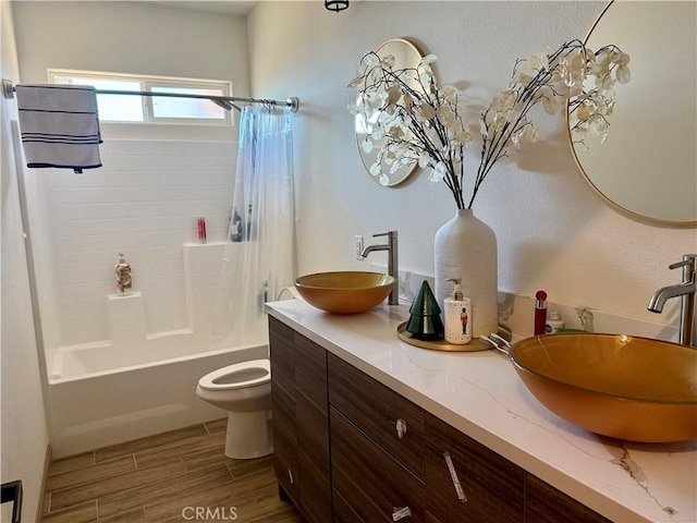 full bathroom featuring shower / bathtub combination with curtain, vanity, and toilet