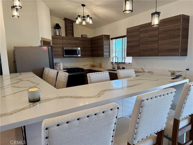 kitchen with sink, stainless steel appliances, and hanging light fixtures