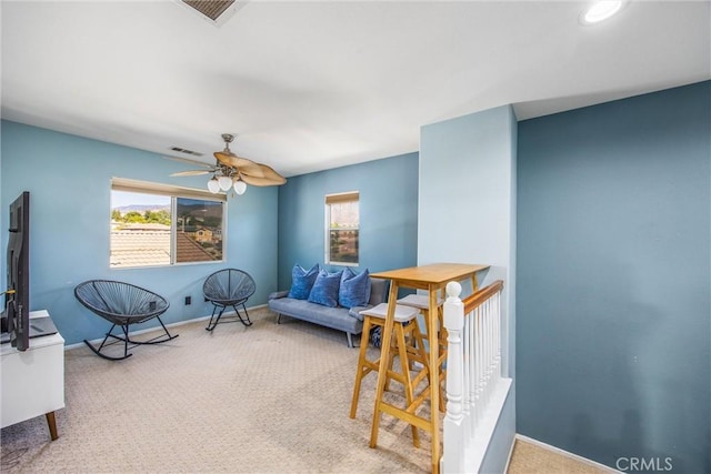 living area with carpet floors, a wealth of natural light, and ceiling fan