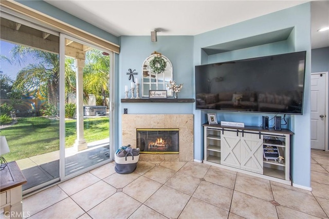 unfurnished living room featuring a tiled fireplace and tile patterned flooring