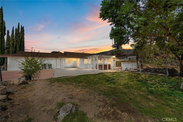 ranch-style home with a lawn, a jacuzzi, and a patio area