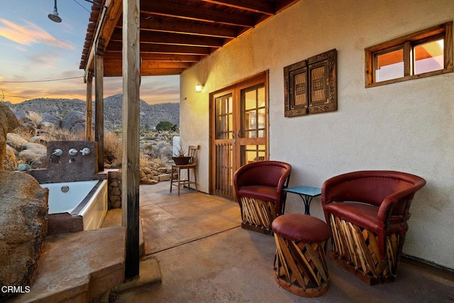 patio terrace at dusk featuring a mountain view