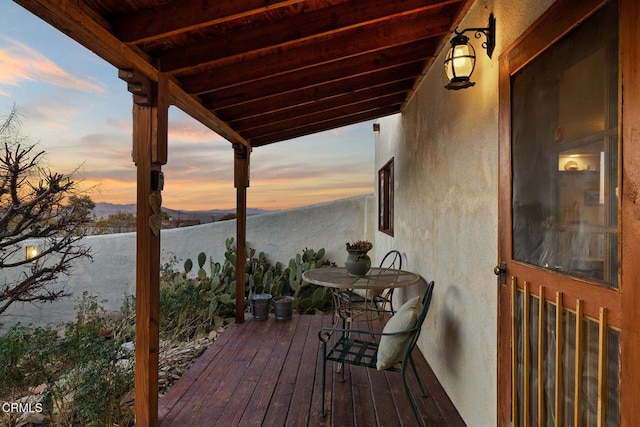 deck at dusk featuring a mountain view