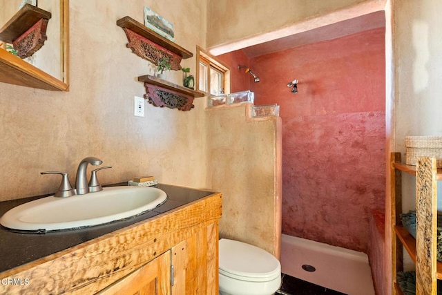 bathroom featuring vanity, toilet, and a shower