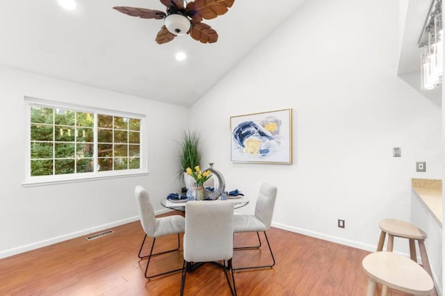 dining area featuring lofted ceiling, hardwood / wood-style flooring, and ceiling fan