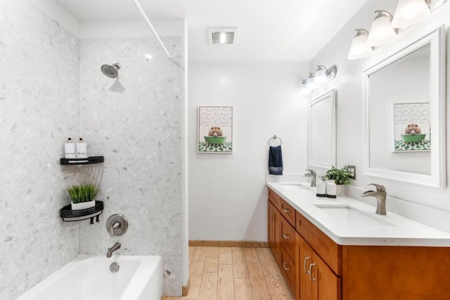 bathroom with tiled shower / bath combo, vanity, and hardwood / wood-style flooring