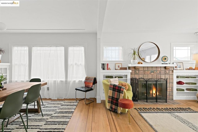 living room featuring hardwood / wood-style floors, a wealth of natural light, and a tile fireplace