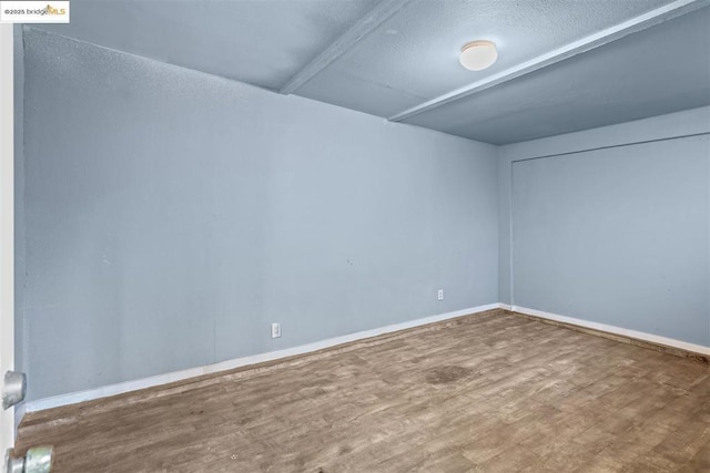 unfurnished room featuring hardwood / wood-style floors and a textured ceiling