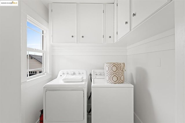 clothes washing area featuring cabinets and washing machine and dryer