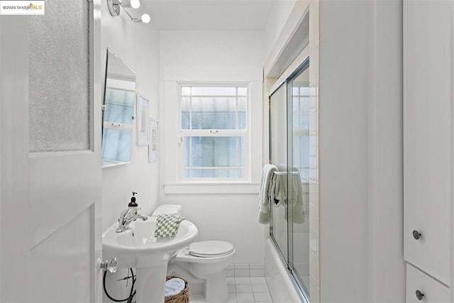 full bathroom with tile patterned flooring, sink, shower / bath combination with glass door, and toilet