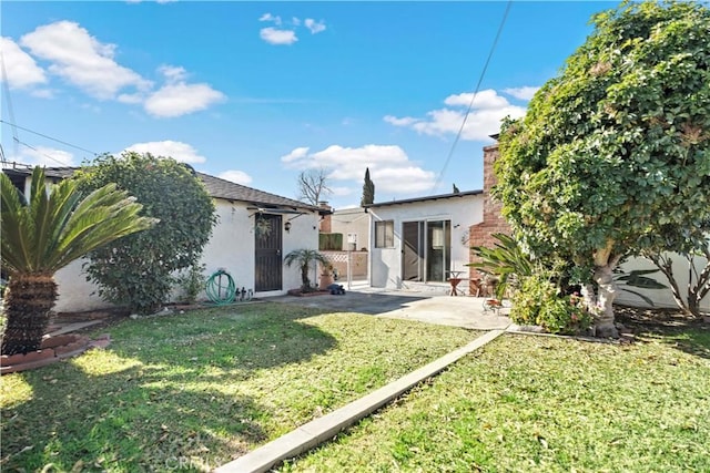 back of property featuring a patio and a lawn