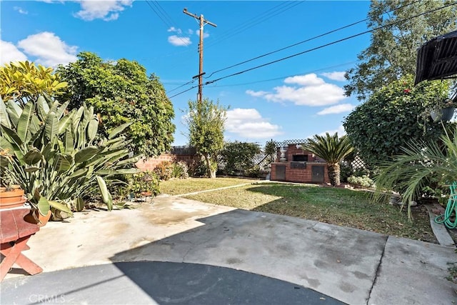 view of yard with an outdoor fireplace and a patio area