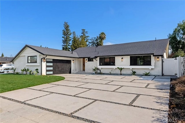 view of front of property featuring a garage and a front lawn