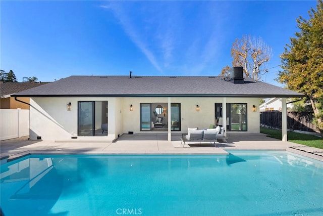 rear view of property with a fenced in pool and a patio area