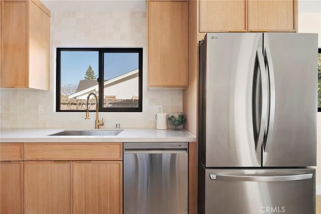 kitchen with appliances with stainless steel finishes, sink, and light brown cabinets