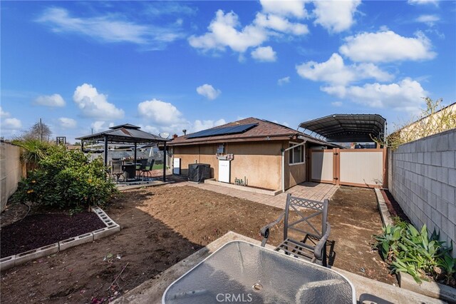 back of house featuring a gazebo and solar panels