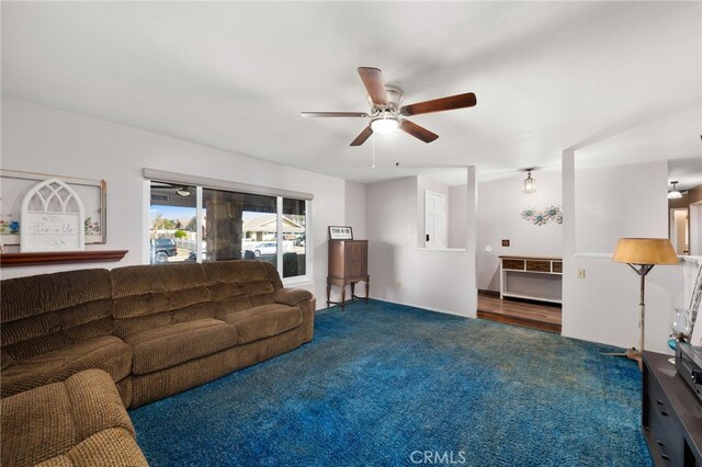 carpeted living room with ceiling fan