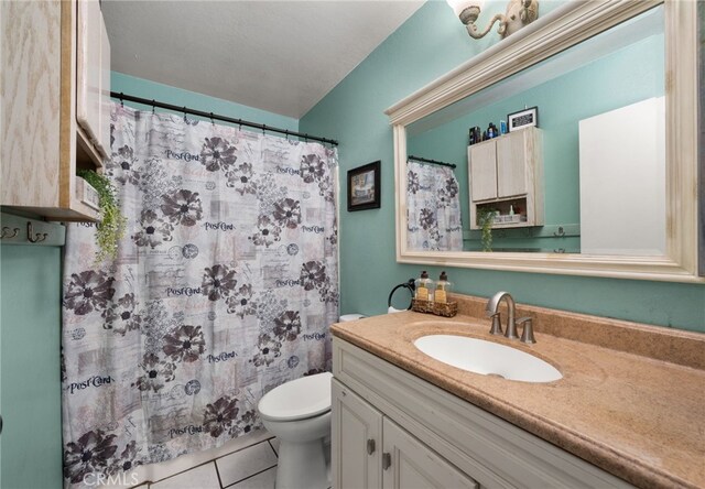 bathroom with tile patterned flooring, vanity, and toilet