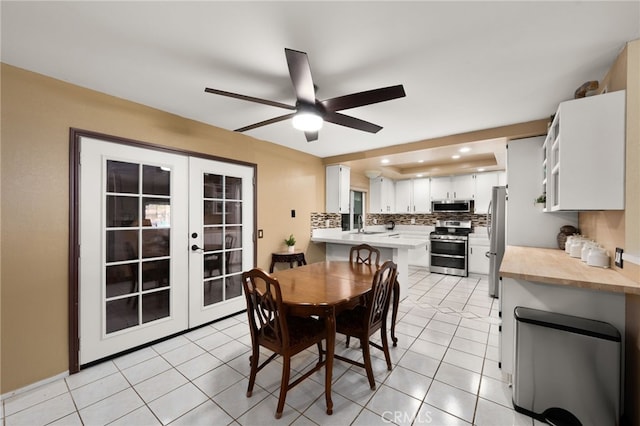 tiled dining space featuring sink, french doors, and ceiling fan