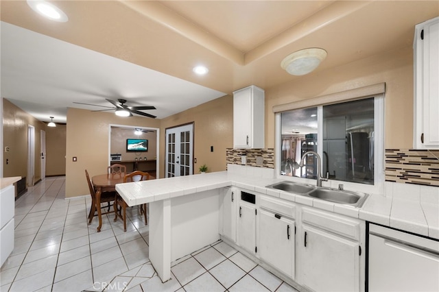 kitchen with white cabinetry, tile counters, and sink