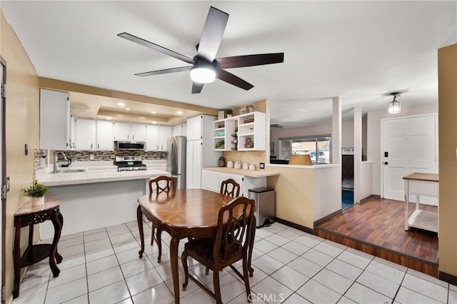 dining room featuring sink, ceiling fan, and light tile patterned flooring