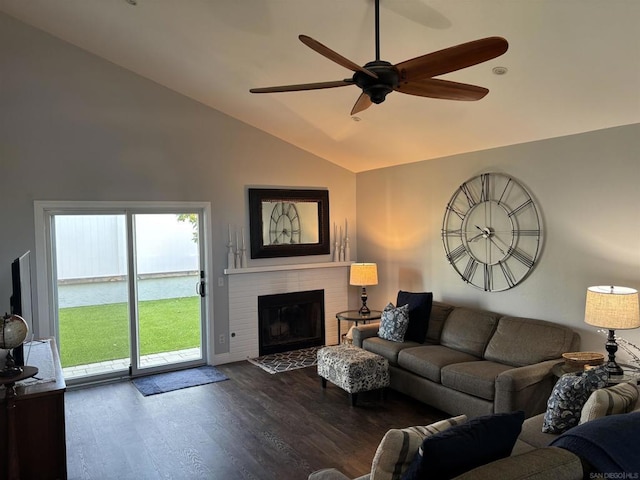 living room featuring lofted ceiling, a fireplace, dark wood-type flooring, and ceiling fan