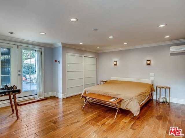 bedroom featuring crown molding, an AC wall unit, access to exterior, and light wood-type flooring