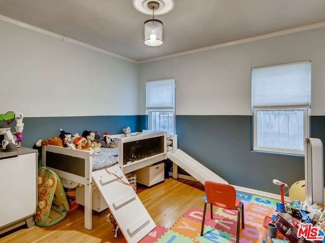 bedroom featuring crown molding and light hardwood / wood-style floors