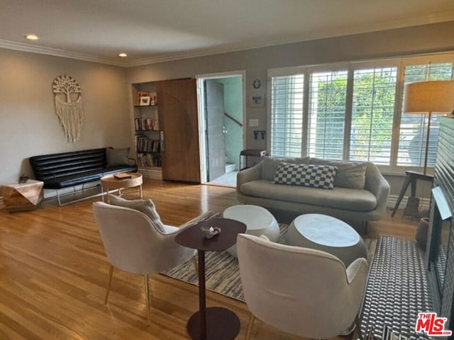 living room featuring hardwood / wood-style floors and crown molding