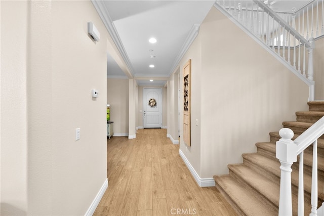 hallway featuring ornamental molding and light hardwood / wood-style floors