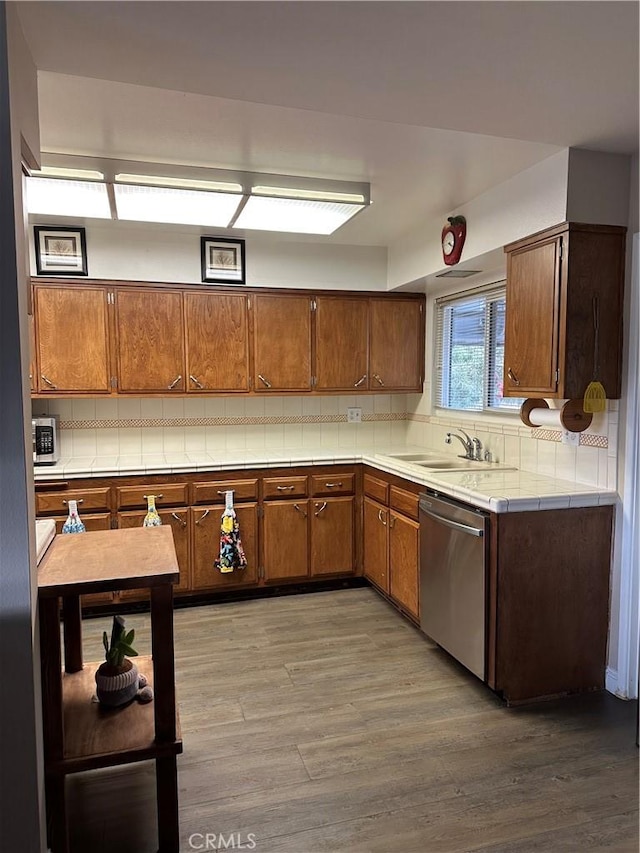 kitchen featuring hardwood / wood-style flooring, stainless steel appliances, sink, and decorative backsplash